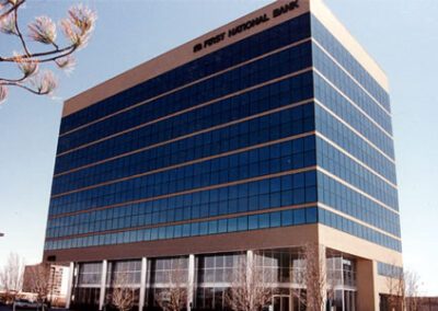 A modern first national bank building with a blue and beige facade under a clear sky.